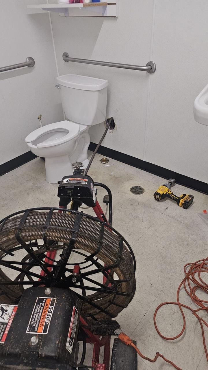 Drain cleaning machine and cable set up in a commercial restroom