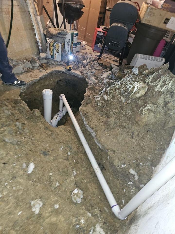 Excavated sewer line with new PVC pipe in the ground
