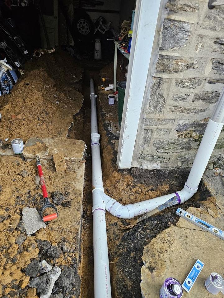 New PVC sewer line run along a foundation wall